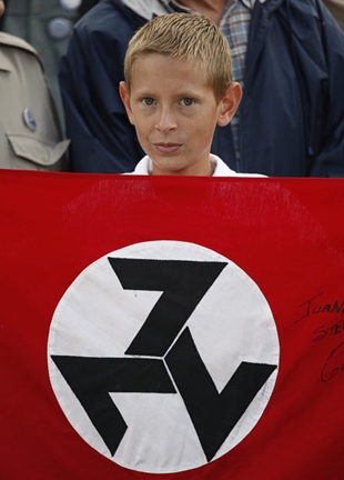 Cativo na manifestaci&oacute;n coa bandeira do AWB, tres setes formando unha esv&aacute;stica