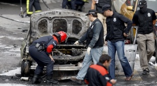 A polic&iacute;a inspecciona o veh&iacute;culo onde estourou a bomba-lapa, este martes en Bilbo