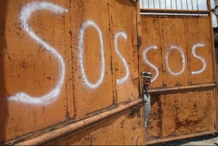 Un usbeco mira desde un port&oacute;n, en Osh