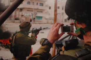 Un soldado t&iacute;ralle unha foto a outro que apunta